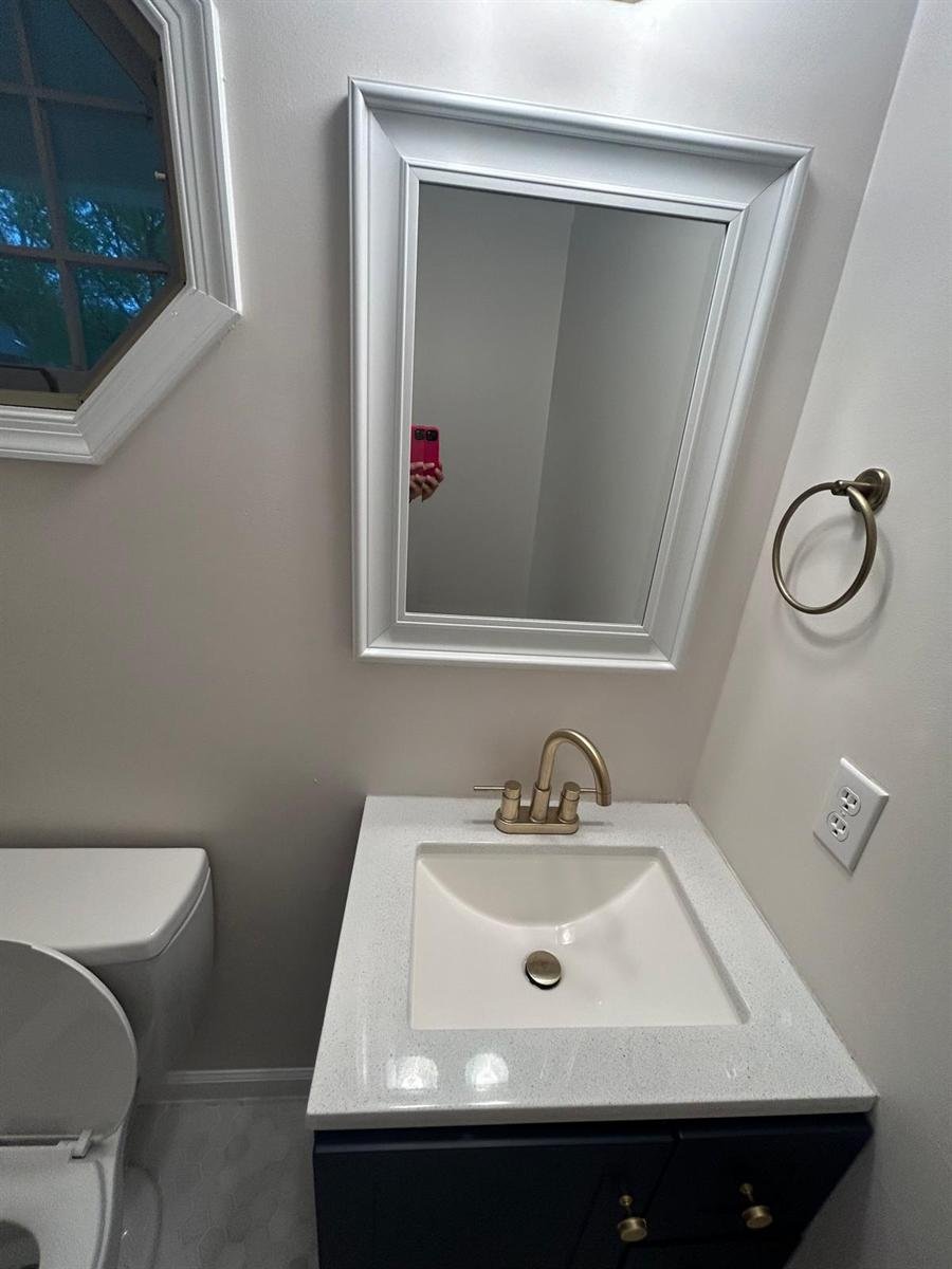 Bathroom vanity, sink and mirror wiped down and polished